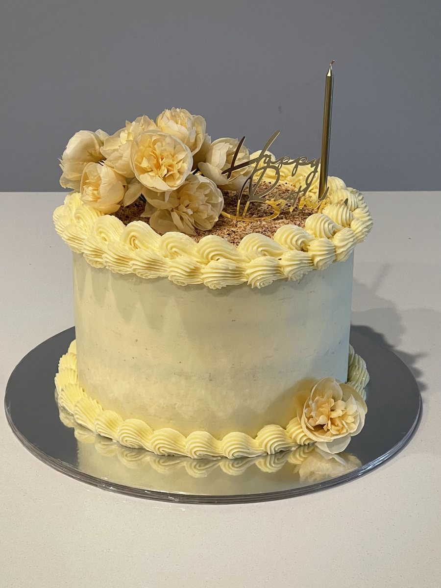 Lemon-yellow cake with piped scallops and dried roses