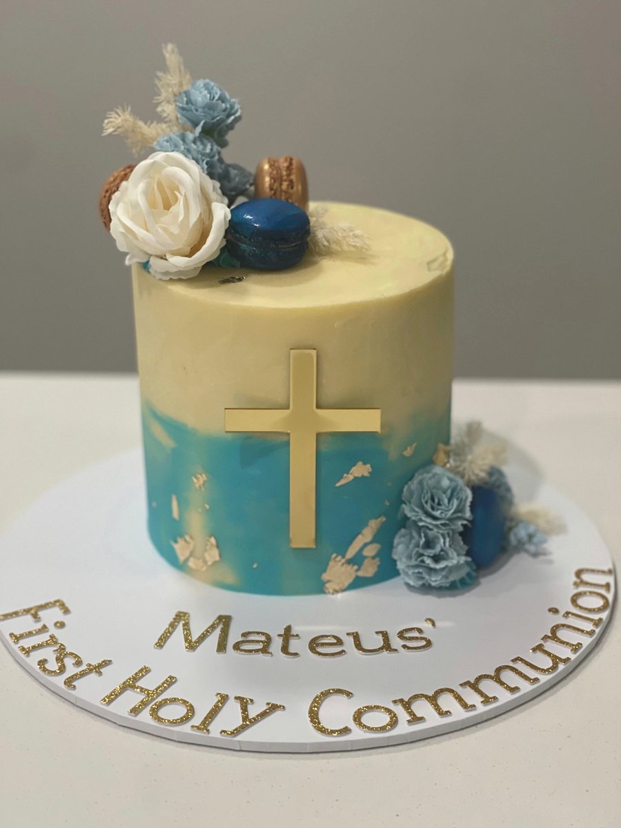First communion cake with a gold cross and blue flowers